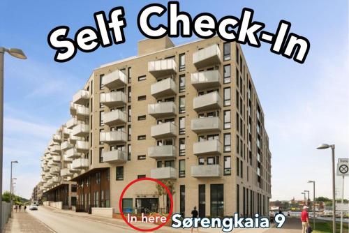 a picture of a building with a sign that reads self check in at SØRENGA Opera, Munch, Fjord & City - Walking distance from Oslo Centralstation in Oslo