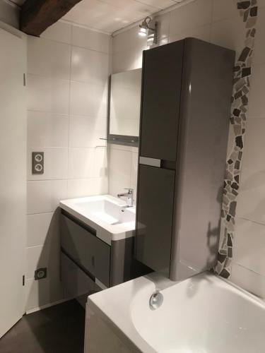 a white bathroom with a sink and a mirror at Am Dàntzwaj in Lembach