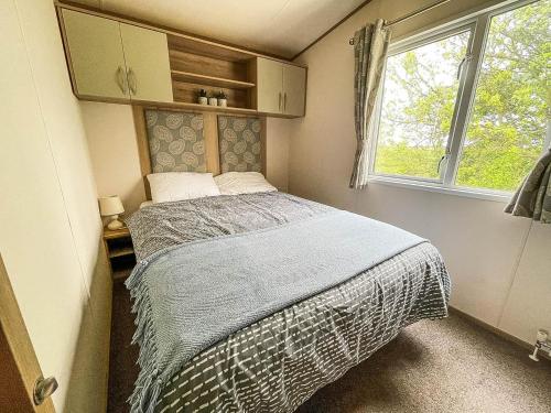 En eller flere senge i et værelse på CaravanSleeps6-HotTub-Garden-WaterWonderland