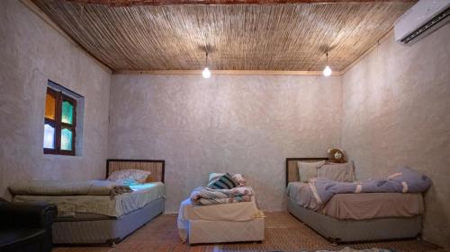 two children laying on beds in a room at Al Khateem Art Hub in Baţīn
