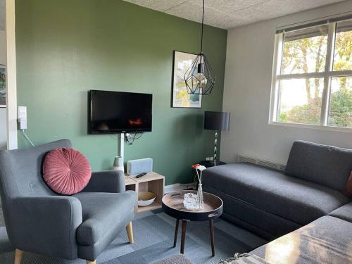 a living room with two couches and a tv at Aneks i rolige omgivelser-adgang til pool og sauna in Avlum