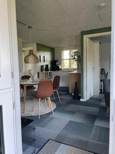 a kitchen and dining room with a table and chairs at Aneks i rolige omgivelser-adgang til pool og sauna in Avlum