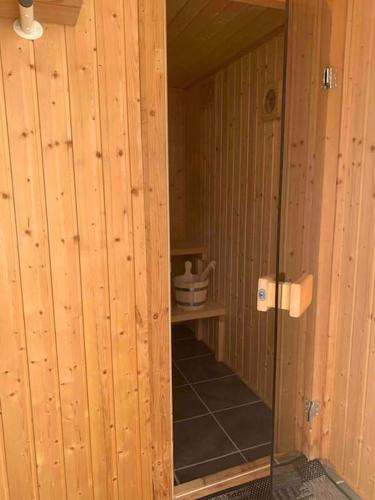a hallway with wooden walls and a glass door at Aneks i rolige omgivelser-adgang til pool og sauna in Avlum