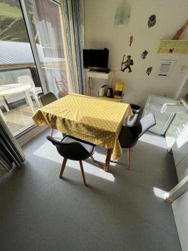 une table et des chaises jaunes dans une pièce dans l'établissement Résidence FACE SUD LA MONGIE, à La Mongie