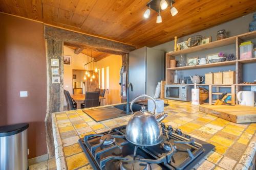 a kitchen with a stove with a tea kettle on it at Maison Time-out in Villevieille