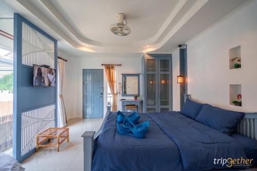 a bedroom with a blue bed and a balcony at พีพี วิลล่า เกาะล้าน in Ko Larn