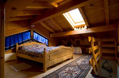 an attic room with a bed and a window at BAITA GRUEPEUN - "baita Laner" in Frassilongo