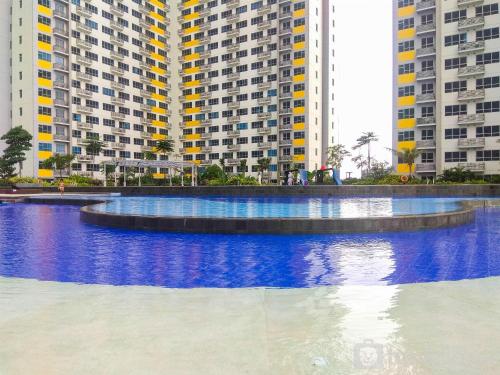 a large pool of water in front of tall buildings at Fancy and Comfy 2BR Apartment at Springlake Summarecon By Travelio in Bekasi