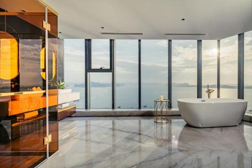 a bathroom with a tub and large windows at Radisson Blu Ha Long Bay in Ha Long