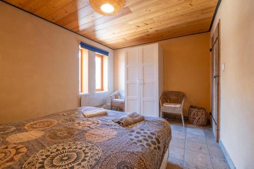 a bedroom with a bed and a wooden ceiling at Maison Time-out in Villevieille