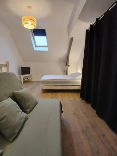 un salon avec un lit et une fenêtre dans l'établissement Studio avec terrasse, à Herbignac