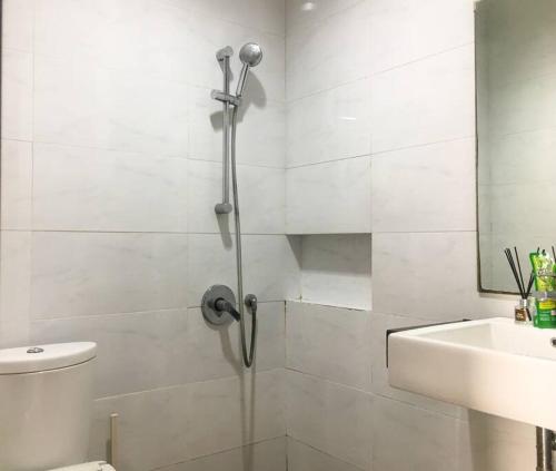 a bathroom with a shower and a toilet and a sink at Sweet Home & Rooms East Asia 17, Greenlake City in Pondokpucung