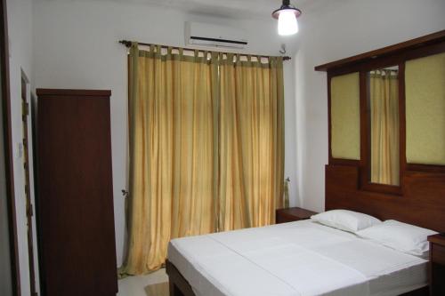 1 dormitorio con 2 camas y ventana en Sagala Bungalow, en Kalutara