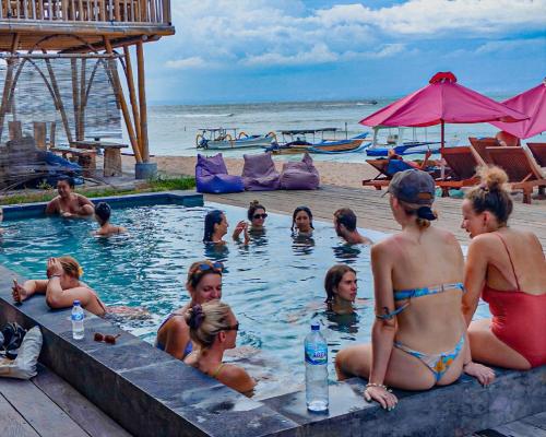 eine Gruppe von Personen in einem Schwimmbad am Strand in der Unterkunft Lushy Hostel Nusa Penida in Nusa Penida