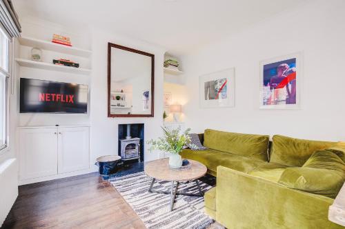 a living room with a green couch and a table at Stylish flat in Shoreditch, Private Roof Terrace in London