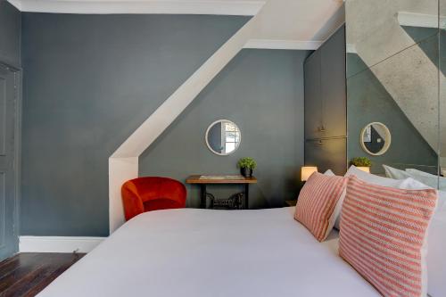 a bedroom with a large bed and a red chair at Stylish flat in Shoreditch, Private Roof Terrace in London