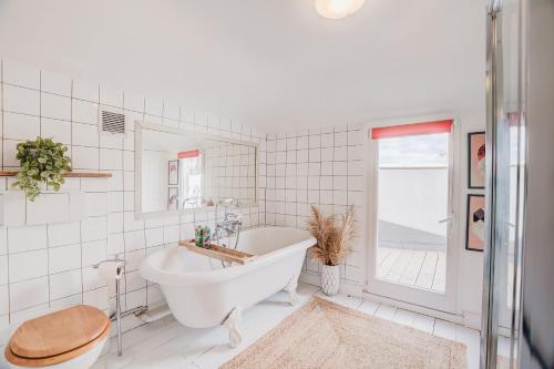 a bathroom with a tub and a toilet and a sink at Stylish flat in Shoreditch, Private Roof Terrace in London