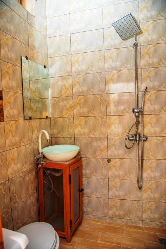 a bathroom with a sink and a shower at AHoefa in Lomé