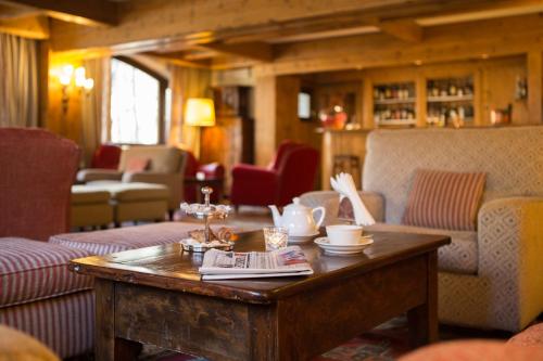 a living room with a coffee table and chairs at Gran Baita Hotel & Wellness in Courmayeur
