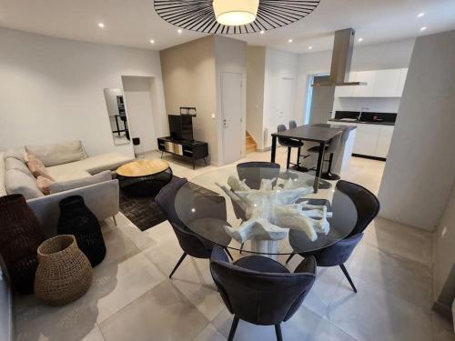 a living room with a glass table and chairs at T4 duplex neuf parking - Aéroport-Eurexpo-Stade in Genas