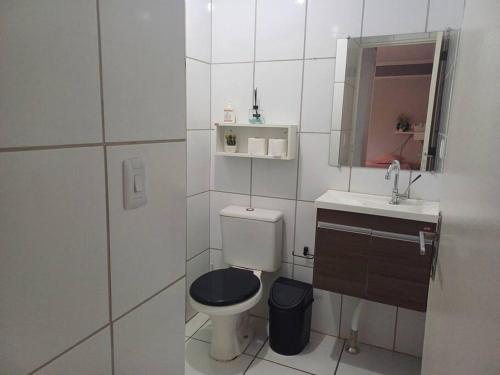 a white bathroom with a toilet and a sink at apto simples,3min centro, 3 min da Unimed com wifi in Araçatuba