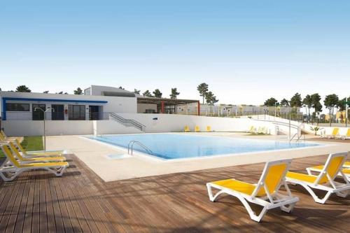 a swimming pool with two chairs and a swimming pool at Villa Palmela Resort V5 Piscina privado in Quinta do Anjo