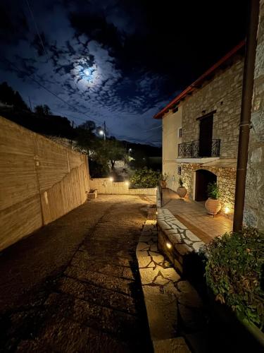 een lege straat 's nachts met de maan in de lucht bij Αύρα House in Arachova