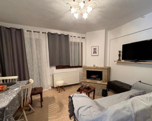 een woonkamer met een bank en een open haard bij Αύρα House in Arachova