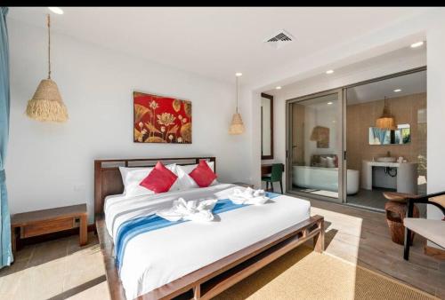 a bedroom with a large bed with red and white pillows at Baan Faahsai碧海半山别墅 in Amphoe Koh Samui