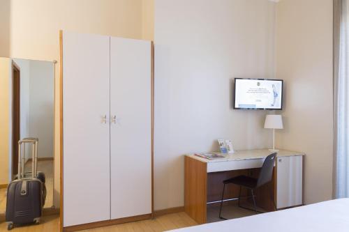 a bedroom with a desk and a large white closet at B&B Hotel Pescara in Pescara