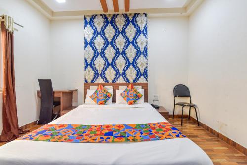 Un dormitorio con una cama grande con almohadas de colores. en FabHotel Shri Shyam Palace, en Ujjain