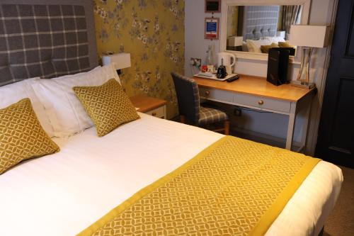 a hotel room with a bed and a desk with a computer at The Woolly Sheep Inn in Skipton