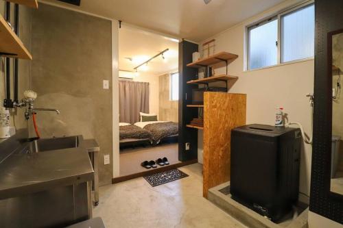Il comprend une cuisine avec un évier et une salle de bains pourvue d'un lit. dans l'établissement urban stay 今泉, à Susakiuramachi
