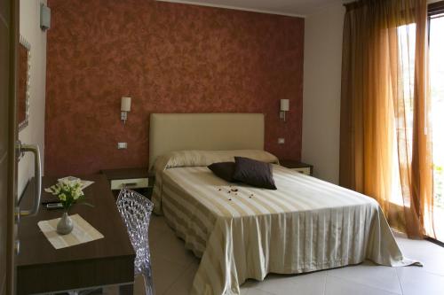 a bedroom with a large bed and a large window at Trigrana Vacanze Hotel in Castelluzzo