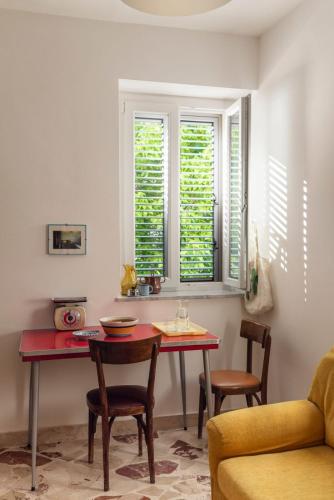 a dining room with a table and chairs and windows at Dazicalò in San Giovanni Gemini