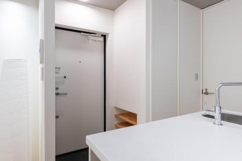 a bathroom with a white door and a sink at trias527 2-4 in Tokyo
