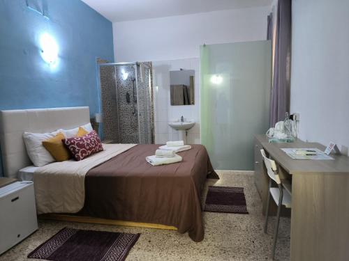 a bedroom with a bed and a bathroom with a sink at Tarona Guesthouse in St Paul's Bay