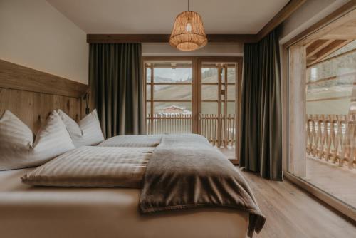 a bedroom with a large bed and a window at FRÄULEIN NANNERL - Boutique Apart mit Saunahaus in Gerlos