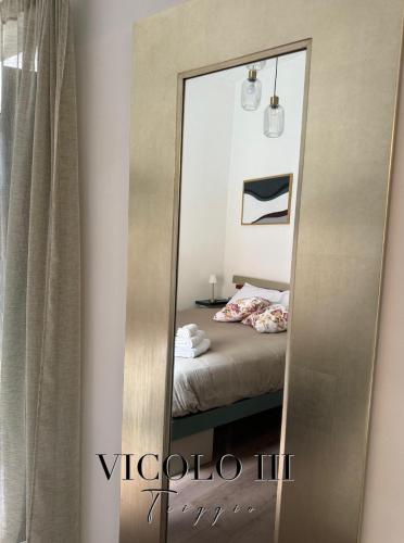 a mirror in front of a bedroom with a bed at Vicolo III Triggio in Benevento