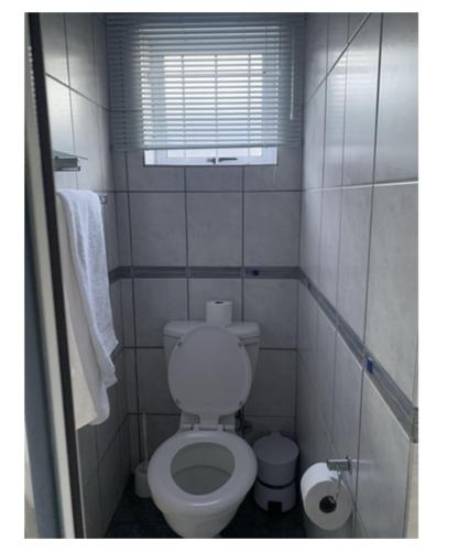 a small bathroom with a toilet and a window at Table Mountain Views in Cape Town