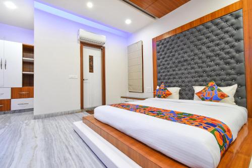 a bedroom with a large bed with a large headboard at FabHotel De Alphabet II - Nr Ameerpet Metro Station in Hyderabad