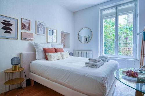 une chambre blanche avec un lit et une table en verre dans l'établissement Studio proche Alesia - Thibaud - II, à Paris