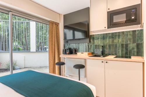 une cuisine avec un évier et un micro-ondes dans l'établissement Maison Menilmontant, à Paris