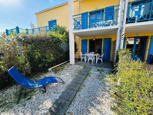 une chaise bleue assise devant une maison dans l'établissement 