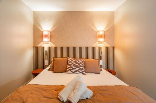 - une chambre avec un lit et deux lumières au-dessus dans l'établissement Merveilleux appartement de luxe au coeurs de Saint-Germain, à Paris