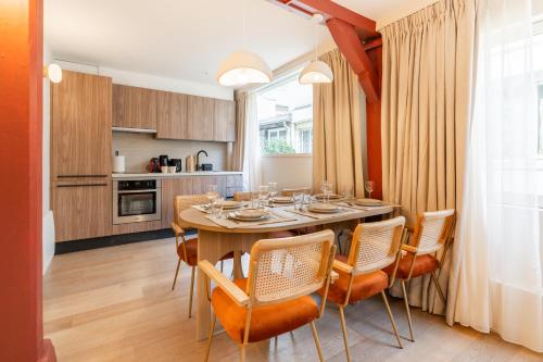 une cuisine et une salle à manger avec une table et des chaises dans l'établissement Merveilleux appartement de luxe au coeurs de Saint-Germain, à Paris
