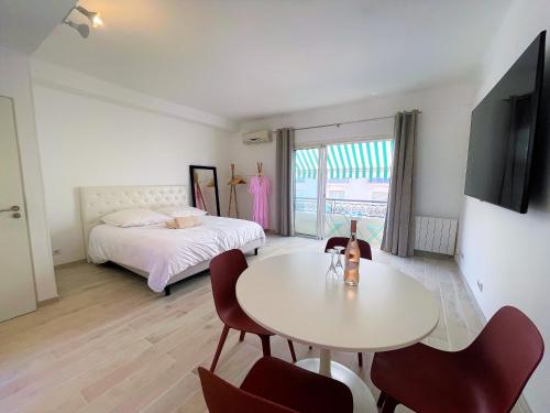 " Pasteur " CityCenter - Terrasse - Congres - VUE MER - Elégant في كان: غرفة نوم بها سرير وطاولة وكراسي