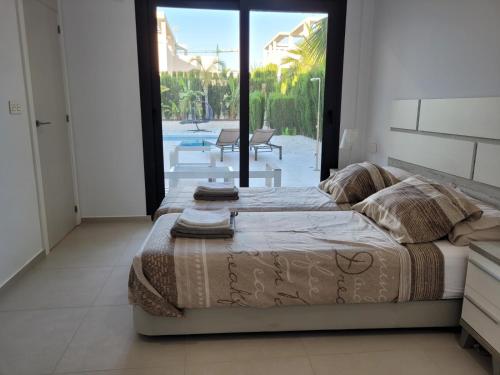 a bedroom with a bed and a view of a patio at La Perla Blanca in Benijófar
