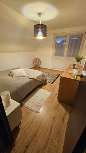 une chambre avec un lit et un parquet dans l'établissement Strasbourg village proximité des marchés de Noël, à Herrlisheim