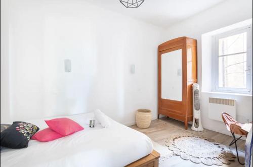 une chambre avec un lit blanc avec des oreillers rouges dans l'établissement Appartement cosy au coeur du panier, à Marseille